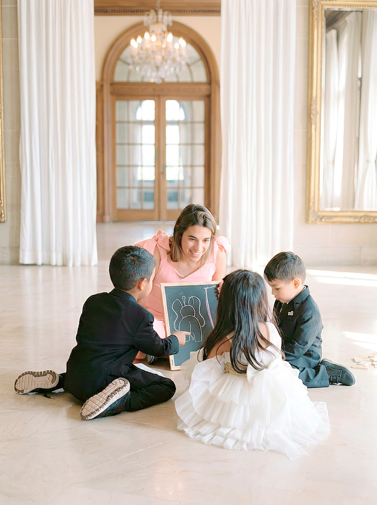 Monitor playing with three children on the floor