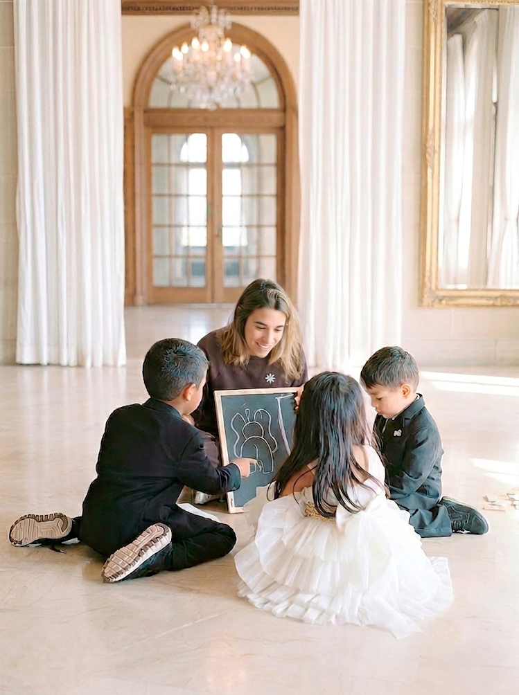 monitora jugando con tres niños en el suelo
